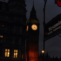 the big ben clock tower towering over the city of london at night with lights on