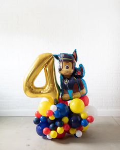 the balloon dog is sitting on top of the number four