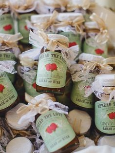 several jars of jams are sitting in a basket with ribbon around them and tied together