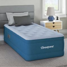 an inflatable mattress is on the floor next to a night stand