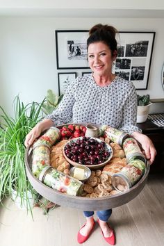 a woman holding a platter full of food