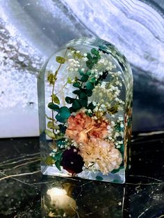 a vase with flowers and greenery is sitting on a table