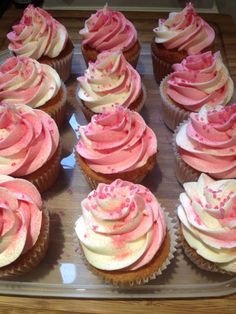 cupcakes with pink and white frosting on a tray