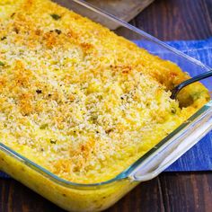 a casserole dish with cheese and broccoli in it on a blue towel