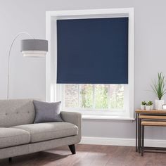 a living room with a gray couch and blue roller shades