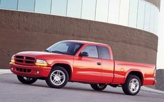 a red pick up truck parked in front of a building