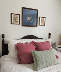 a bed with pillows and pictures on the wall