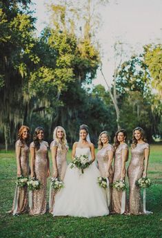 a group of women standing next to each other on top of a lush green field