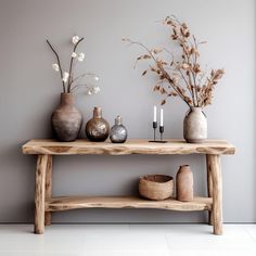 a wooden table with vases and candles on it