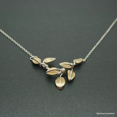 "Sterling silver and brass leaf necklace. This listing is for an all hand made necklace with a silver frame and silver tendrils and brass leaves. The brass leaves are hand saw pierced from brass sheet. The silver frame is 2\" wide approx. and is supplied with a medium weight sterling silver trace chain giving the necklace an  overall length of 18\"  All my jewellery comes in a presentation gift box.  All my designs are hand made and no two are exactly the same.   Thank you for visiting. Please note that international shipping fees do not include possible custom charges for your country and you will be solely responsible for payment of these charges.  We are required by law to fully disclose the contents and value of the items in your package for Customs purposes.  Your local customs office Nature-inspired Silver Brass Necklaces, Nature-inspired Silver Brass Necklace, Pearl Ring Simple, Sterling Silver Leaf Necklace, Silver Initial Ring, Bronze Bangle, Oak Leaf Necklace, Silver Earrings Wedding, Brass Sheet