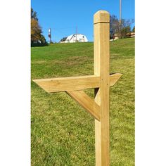 a wooden cross sitting on top of a lush green field