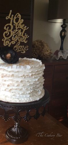 a cake with white frosting sitting on top of a table