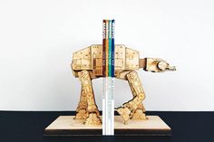 a wooden model of a star wars at - at with two books in front of it