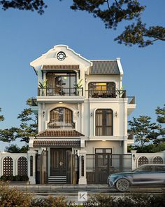 a car is parked in front of a large white house with balconies on the second floor