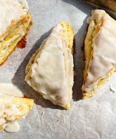 glazed scones sitting on top of a piece of parchment paper