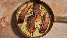 a pan filled with meat and sauce on top of a table