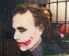 a man dressed as the joker in a jail cell