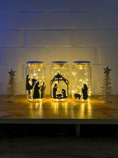 three mason jars with nativity scene in them