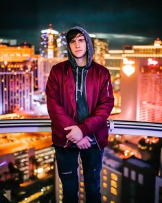 a man standing on top of a tall building in front of a cityscape