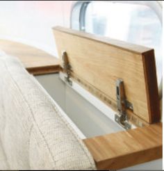 the back end of a couch with a wooden box on it's armrest