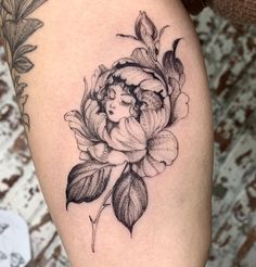 a woman's thigh with a flower tattoo on it