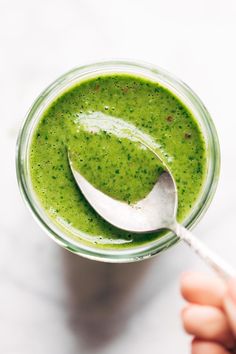 a spoon in a jar filled with green liquid