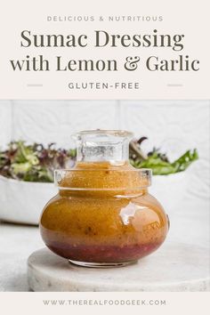 a glass jar filled with lemon and garlic sauce on top of a white countertop