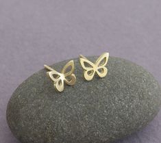 "14k gold butterfly stud earrings. Pretty and dainty earrings, handmade of solid 14k gold. I cut each butterfly with a jeweler's saw, from a solid gold sheet, file it, and solder a 14k gold post to the back of each one. I give the small butterflies a shiny mirror-like finish. You can choose between a few options: A cute mismatched pair - one butterfly flat and the other is with raised wings. A pair of flat earrings. Or pair with raised wings. Butterflies symbolize hope, transformation, rebirth a Dainty Yellow Gold Earrings With Butterfly Charm, 14k Gold Butterfly Earrings For Gift, Flat Earrings, Butterflies Symbolize, Small Butterflies, Tiny Gold Earrings, Dainty Gold Earrings, Earrings Pretty, Classy Earrings