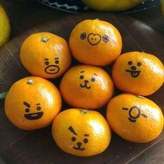 a pile of oranges with faces drawn on them