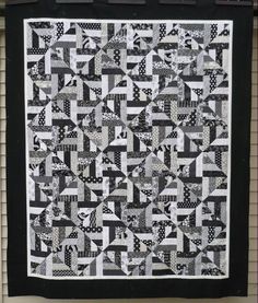 a black and white quilt hanging on the wall