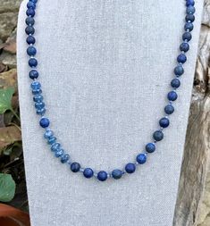 This necklace is matte lapis lazuli of varied shades of medium to dark blues, spaced with softly shaded blue sodalite and  accented with a segment of beautiful blue kyanite. 24 inches in length this necklace easily slides over your head without a clasp. Lapis Lazuli - is a protective gemstone said to help relieve stress and bring deep peace. Said to alleviate pain, especially headaches  Kyanite - is said to stimulate intuition and help to speak one's truth. Sodalite - is one of the stones that h Blue Kyanite Gemstone Bead Necklaces, Blue Kyanite Gemstone Beaded Necklace, Blue Kyanite Gemstone Necklace, Blue Lapis Lazuli Natural Stone Necklace, Blue Lapis Lazuli Necklace With Natural Stones, Blue Lapis Lazuli Round Beads Crystal Necklace, Blue Lapis Lazuli Crystal Necklaces With Round Beads, Blue Lapis Lazuli Gemstone Bead Necklaces, Blue Lapis Lazuli Beaded Gemstone Necklace