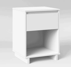 a white nightstand with an open shelf on the bottom and one drawer at the top