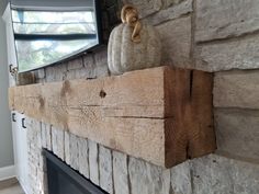 a fireplace with a mantle made out of wood and a mirror on top of it