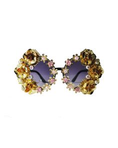 These dramatic gold floral sunglasses will make you feel ultra fabulous- the compliments are guaranteed OFF THE CHARTS! These plastic frames have round shaped dark tinted lenses and feature an all-over hand embellished frame with assorted flower accents. Each pair is one-of-a-kind and as unique as you are. As if it couldn't get anymore fabulous, these sunnies are complete with a removable neck chain strap with pearl embellishment attached at each temple! These super fun sunglasses ship with a cl Chic Round Frame Sunglasses For Party, Bohemian Sunglasses For Summer Parties, Elegant Gold Sunglasses For Summer, Party Sunglasses With Round Glass Frame, Vintage Round Frame Sunglasses For Party, Gold Round Frame Sunglasses For Party, Gold Round Frame Party Sunglasses, Party Round Frame Glass Sunglasses, Gold Metal Sunglasses For Party