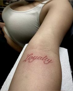 a woman's arm with the word joy tattooed on her left arm, in cursive script