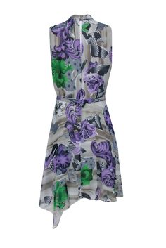 Make a fierce fashion statement in this dazzling dress from Versace, featuring an eye-catching abstract floral print in bold pops of purple, green, and navy. Boasting polished pleats, a high neckline, and a chic gold logo belt, this dress flatters with flirty ruffles and a flattering a-line silhouette. Style it with pumps and a patent leather clutch for the ultimate statement look! Size 8 100% Polyester Lined Concealed back zip w/ snap buttons Attached belt Open keyhole back w/ buttons Sleeveless A-line Wrap style Asymmetrical ruffled hem High neckline Bust 35" Waist 30" Shoulder to hem (left) 39" Shoulder to hem (right) 43" Chic A-line Dress With Abstract Print, Spring Evening Dresses With Multicolor Print, Multicolor Print Evening Dresses For Spring, Green Abstract Print Party Dress, Spring Evening Dresses In Multicolor Print, Spring Evening Multicolor Print Dresses, Chic Green Dress With Abstract Print, Summer Workwear Dresses With Abstract Print, Abstract Print Dress For Spring Workwear