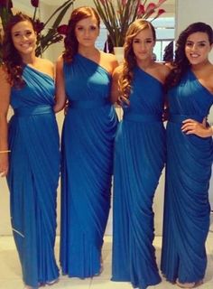 four beautiful women in blue dresses posing for the camera