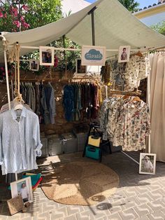 an outdoor clothing store with clothes hanging on the rack and pictures hung up to dry