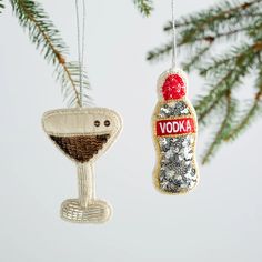 an ornament hanging from a christmas tree next to a glass bottle with vodka on it