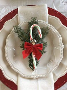 a white plate topped with candy canes and a christmas decoration on top of it