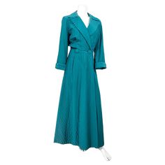 Late 1940s to early 1950s dark teal green quilted house robe/coat featuring a double button closure with designer covered buttons, a wide peak lapel, rolled and cuffed full length sleeves. The interior is fully lined with a rose salmon colored lining fabric. 16 inch shoulder up to a 38 inch bust 26 inch waist 56 inch length Retro Wardrobe, Dark Teal Green, Peak Lapel, Green House, Salmon Color, House Dress, Color Lines, Dark Teal, Lining Fabric