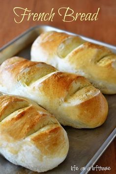 freshly baked bread sitting on top of a baking pan with the words french bread written above it