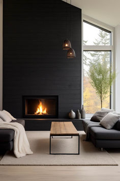 a living room with black walls and a fire place in the center, along with two couches