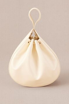 Ivory crossbody bucket bag with corded handle detail. - Aza Fashions Cream Evening Bucket Bag In Pouch Shape, Cream Evening Bucket Bag Pouch, Evening Cream Bucket Bag, Cream Bucket Bag With Adjustable Strap For Evening, Cream Crossbody Bucket Bag For Evening, Cream Top Handle Bucket Bag, Cream Bucket Bag With Detachable Handle For Evening, Cream Crossbody Bucket Bag With Handles, Cream Bucket Bag With Handle Drop