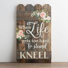 a wooden sign that says, when life gets too hard to stand kneel on