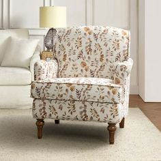 a living room with a white couch, chair and lamp on the side walk way