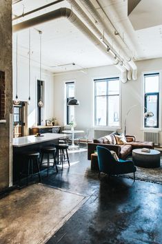 a living room filled with furniture and lots of windows next to a kitchen counter top