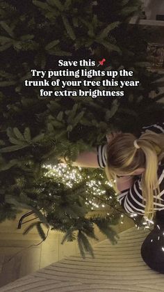 a woman sitting on the ground next to a christmas tree with a quote above it