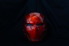 an iron man mask is shown against a black background in this image, it appears to be red