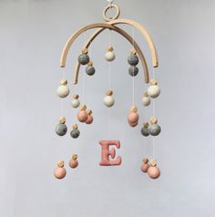 the letter e is made out of rocks and wood with beads hanging from it's sides